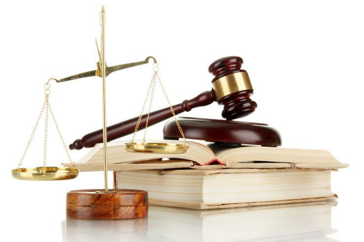 Golden scales of justice, gavel and books isolated on white