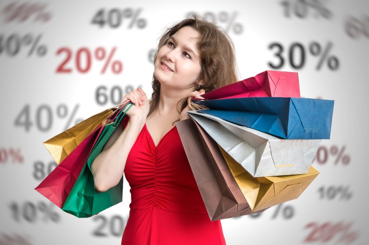 Discounts and shopping concept. Young and happy woman holds many bags.